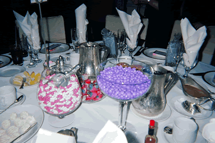 Example of a wedding candy buffet on guests tables Candy arranged by colors