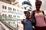 Lisa Moore leaves Mercy Ships with her mother, Teta, the day after her successful cataract surgery on her left eye.  She is given a pair of sun glasses to protect her eyes from the bright sunlight & dusty environmental conditions. They must be worn until Lisa is reviewed at the Mercy Ships eye clinic in Monrovia, 2 weeks after her operation.