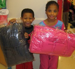 Smiling children holding winter coats