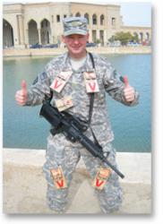 U.S. soldier stands with Victor Rodent Control trap donations.