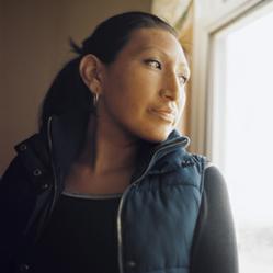 Lakota Sioux woman looks out window hoping for her children.