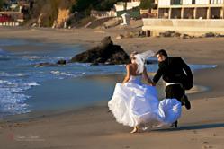 bride and groom running on beach