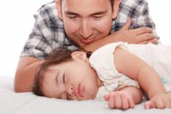 Dad watching baby sleep