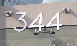 Modern house numbers on store front in brushed aluminum