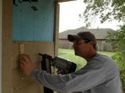 Kyle Burchart, Director of Business Development for Conexus, carefully places siding on a Habitat for Humanity home in Tulsa.