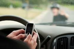 a distracted driver looks at her cellphone