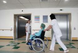 a nursing home patient is wheeled by an aid.