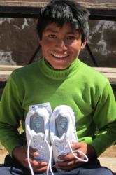 Mauricio from Peru displays his new shoes from Buckner International's Shoes for Orphan Souls.