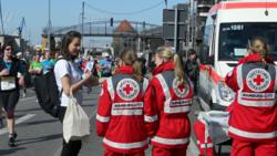 Volunteer from the Church of Scientology Hamburg hands a copy of The Way to Happiness to ambulance workers on duty at the Hamburg Marathon April 21.
