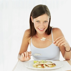 Young woman eating fish