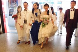 Above: With brides and grooms in hand, a happy matchmaker Hellen Chen (Center) strides forward with the message that believing in love again can heal broken hearts.