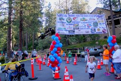 A young athelete crosses the finish line during the first My Tri Mountain Area Youth Triathlon at Bass Lake last Saturday.