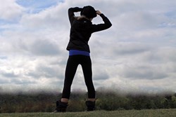 Beautiful athletic girl wearing TerraFrog yoga pants hiking up a mountain.