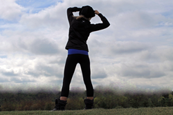 Beautiful athletic girl wearing TerraFrog yoga pants hiking up a mountain.