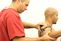 dr shoshany using rocktape to help assist the shoulder joint