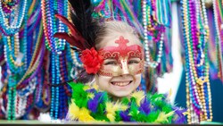 A photo of a kid in a Mardi Gras mask