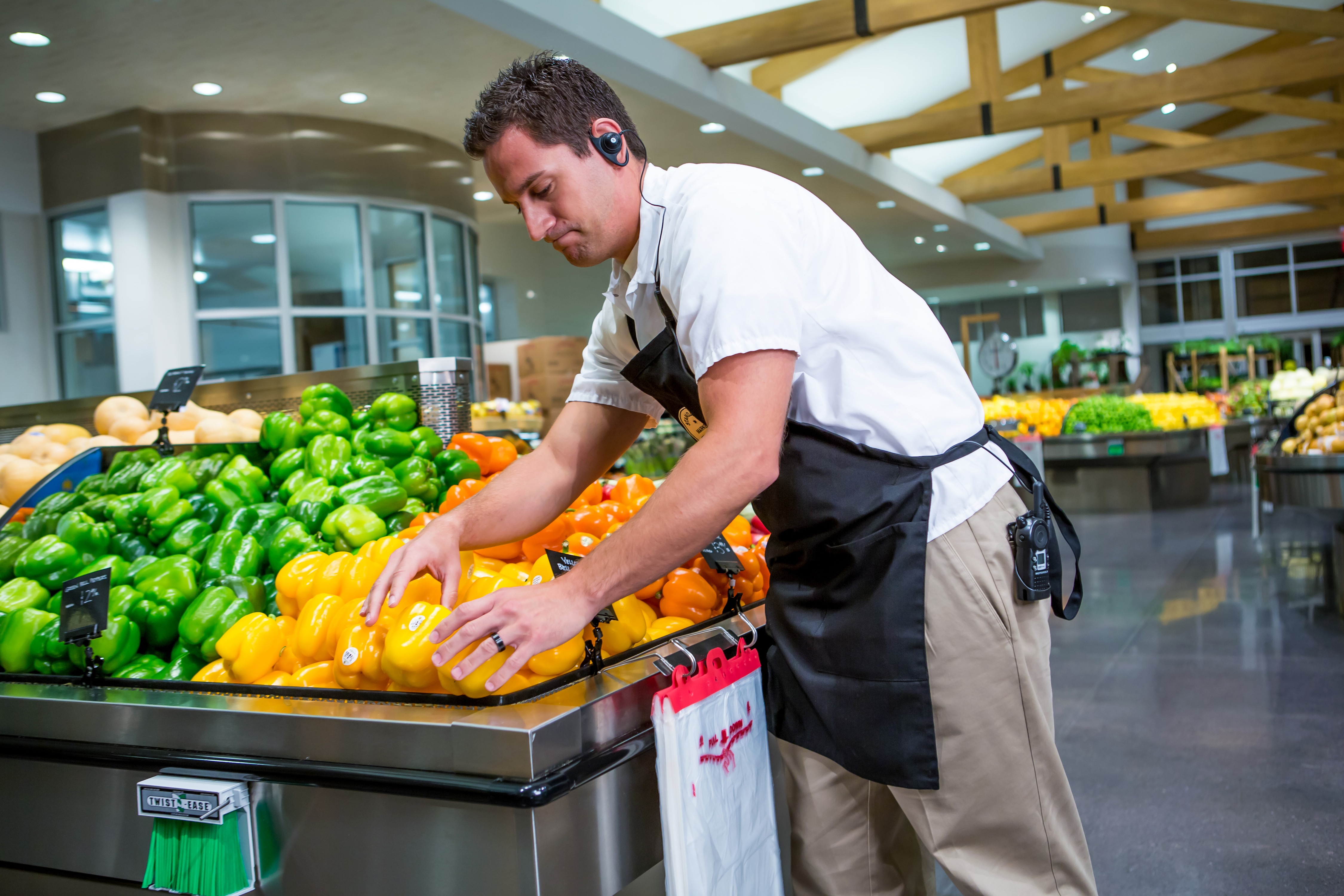 portrait-of-store-clerk-standing-at-counter-in-supermarket-stock-photo