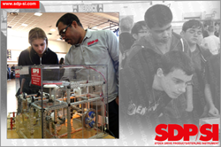 Orville Ashley showing a student a mechanical drive display, showcasing some of the parts that SDP/SI offers and how they can be used in an application.