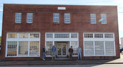 The Outer Banks Distilling team in front of the historic downtown Manteo building they are renovating into the distillery.