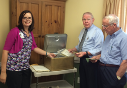 Current and former leadership at Piedmont Crossing sift throught contents in time capsule.