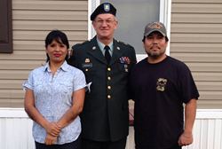 Three people in front of a home