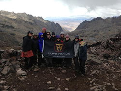 Women at the top of mountain holding Travis Manion Foundation flag.