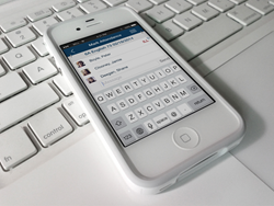 iPhone resting on keyboard, running VS School MIS app