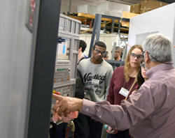 Aman Noory (SDP Manufacturing Manager) showing explaining a CNC Machine to Hofstra Students.