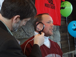 Judge analyzing the beard of BMS Movember participant Bob Nice.