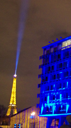 The Eiffel Tower provides emphasis to a light artwork on the UNESCO headquarters building celebrating the International Year of Light.