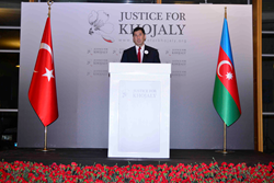 Man standing by Justice for Khojaly screen