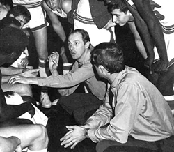 Coach Fletcher Arritt huddles with his team during a game in the 1970s