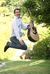 Singer Songwriter Michael Ryther jumps with guitar