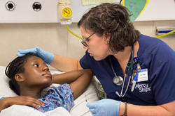 Mercy Ships volunteer nurse Anna Iraggi examines Mona as she recovers from a free operation onboard the Africa Mercy in Madagascar