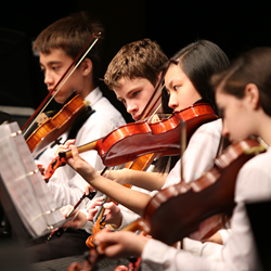 Young violin students performing at a school concert.