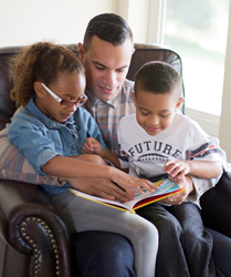 Parent reading with his children.
