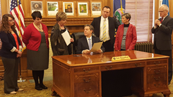 Members of the Kansas Coalition for Problem Gambling watch as Governor Sam Brownback signs a Proclamation commemorating Problem Gambling Awareness Month.
