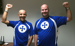 Cane Bay Partners Chief Risk Officer Mehran Chirehdast and Software Development Manager Jeff Dykstra try on the athletic shirts freshly made for their upcoming participation in the Ironman 70.3 Triathlon under the Team Cane Bay VI banner.