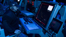 Chief Air Traffic Controller Keith Thompson demonstrates the first air traffic control simulator installed on board the aircraft carrier USS Carl Vinson