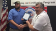Marcus Irvine accepts the EF16@IWCE Veteran scholarship from Veterans Assembled electronics CEO John Shepard.