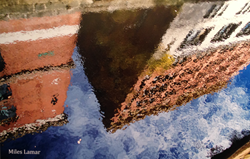 Photograph by Husson University student Miles Lamar of buildings reflected in water.