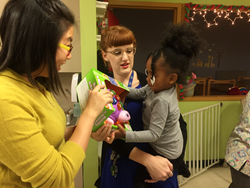 Photo of Fareportal employee delivering gift to child at Covenant House