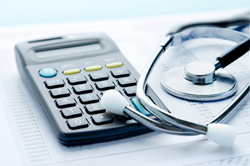 A calculator and stethoscope on a medical bill
