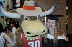 Texas Longhorn mascot with arm around graduating student