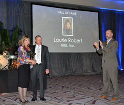 Laurie Robert is presented with the MBI Hall of Fame Award by Bob McNeil, President of NRB Inc. Congratulating Laurie is Tom Hardiman, Executive Director of the Modular Building Institute.