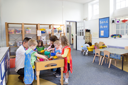Children Interacting at Sensory Tables in Classroom