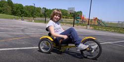 A young girl is one of more than 730 children in Adams County, Ohio whose local schools received adapted bikes through a national pilot program to improve access to healthy activities for people with disabilities. A new video series highlights this and other work in 10 communities in five states through a partnership between the National Association of Chronic Disease Directors, CDC, Lakeshore Foundation, and the National Center on Health, Physical Activity and Disability.