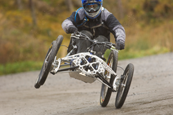 Adaptive four-wheel downhill mountain bike on a trail.
