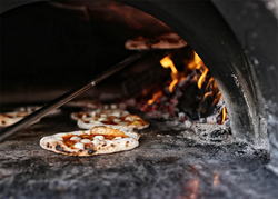 Photo of pizza going in pizza oven at Pizzeria Vetri