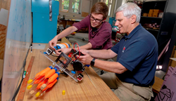 William Godsey ’18, left, and Bradley Miller, associate director of WPI’s Robotics Resource Center, examine the lionfish harvesting robot built by Godsey and his project team.